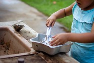 image of childs hand playing in mud