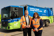 Two councillors in front of an electric refuse collection vehicle