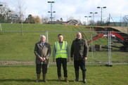 Three people stood in front of the amphitheatre construction site