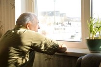 Elderly gentleman looking out of window