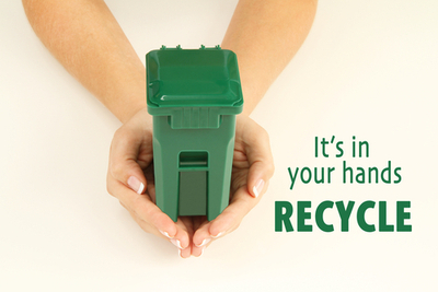 Hands holding green recycling bin