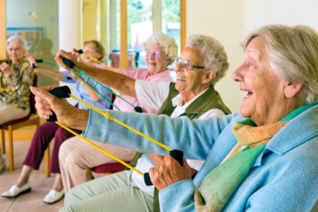 Older people exercising while sat in chairs