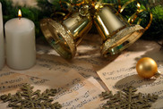 sheet music with candles and gold bells in the background