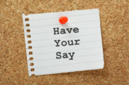 Paper with 'Have your say' printed on pinned to cork board