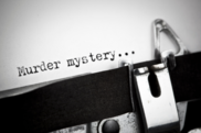Old fashioned typewriter. Paper says 'murder mystery'.