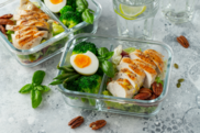 Chicken, egg, broccoli and salad leaves in a clear sandwich box