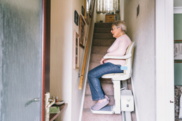 Elder lady using a stair lift in a home