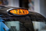 Taxi Sign on top of a black cab