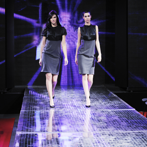 Two models walk down a runway