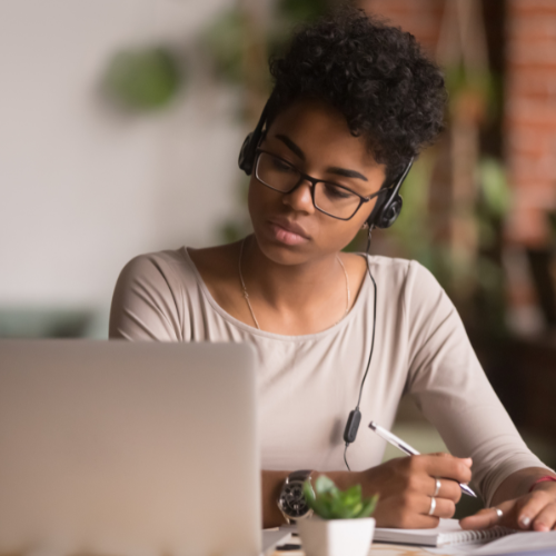 A woman sits at her laptop looking at something on the screen