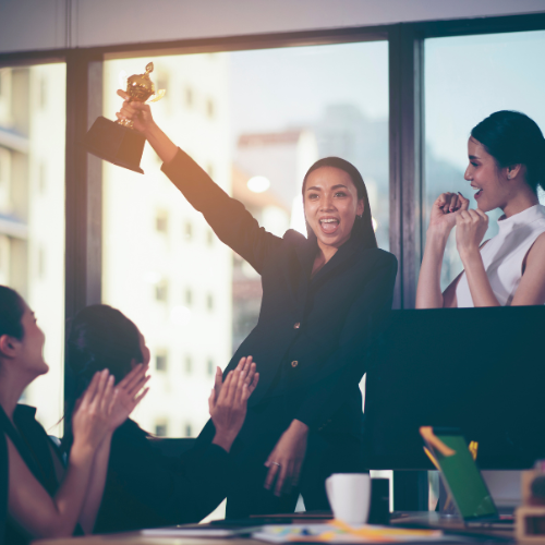 A room of women holding an award and celebrating