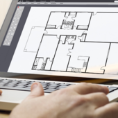Someone uses a laptop to design a floor plan for a building