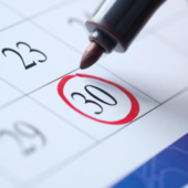 A pen circles a date in a calendar 