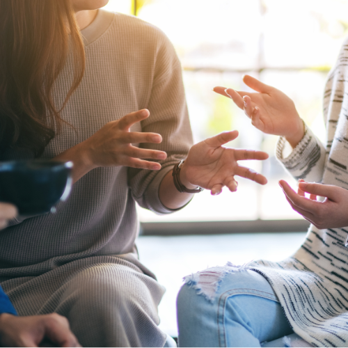 Two women discuss something, with their body language communicating their interest