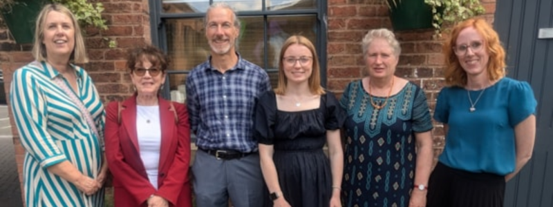 A group of people stand looking at the camera and smiling