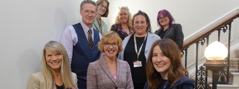 A group of people stand on the stair case of York Register Office looking at the camera and smiling
