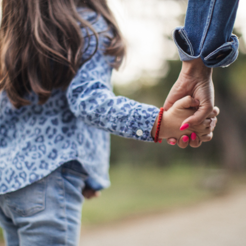 adult holding child's hand