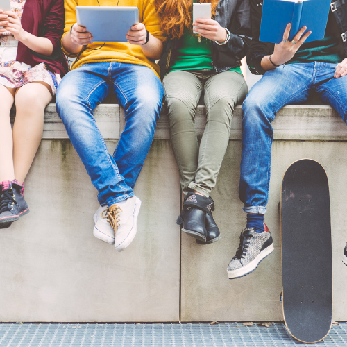 Group of young people sat on a wall