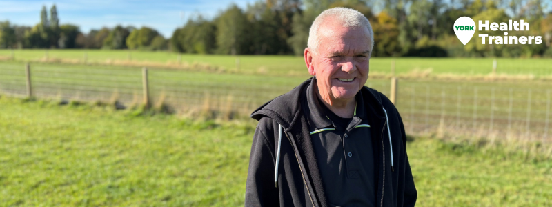 A smiling man walks across a field