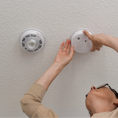 Alarms being adjusted on a ceiling