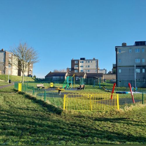 A playground with homes in the background