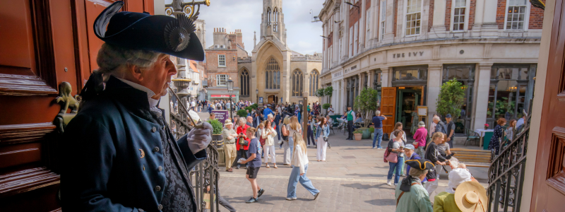A photo of a man in Georgian costume looking out onto St Helen's Square