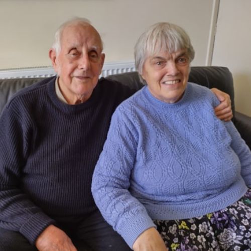 A man and woman sitting on a sofa