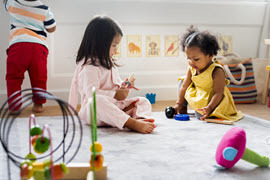 Little kids playing with toys in a playroom