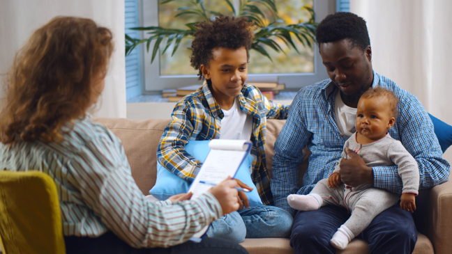 Case worker interviewing a man with two children