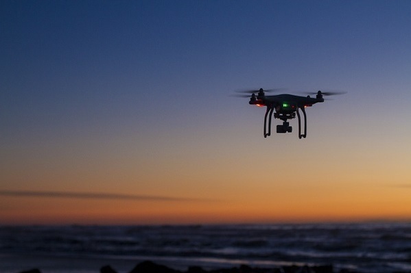 Drone flying over ocean in sunset