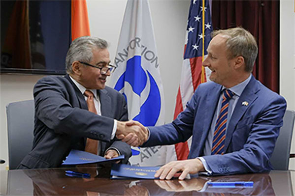 FAA and EU officials signing agreement and shaking hands