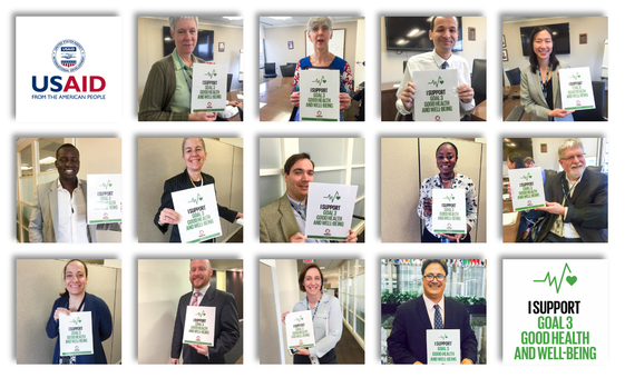 Staff at USAID hold up signs supporting goal 3: Good Health and Wellbeing