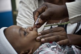 A child receives an oral polio vaccine in Uganda. 