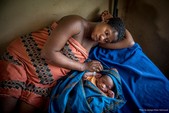 Mother and child laying on bed together.