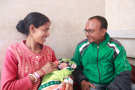 New parents hold their baby