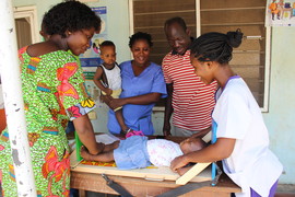 A supervisor coaching a health worker on measuring child growth