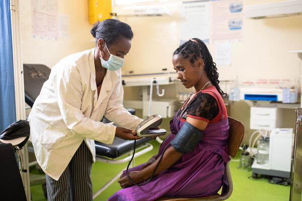 Health worker taking blood pressure for a pregnant woman