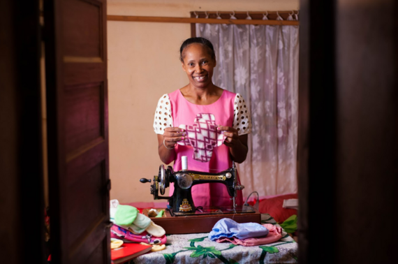 Vola, a professional seamstress in Madagascar, holds up a reusable pad that she sewed. 