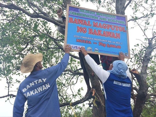  Silonay Mangrove Conservation and Ecopark Mangrove Wardens install a sign stating that cutting mangroves is not allowed and carries a fine.