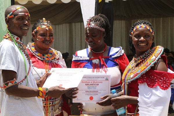 Ujuzi Manyattani graduates display their certificates after the graduation.