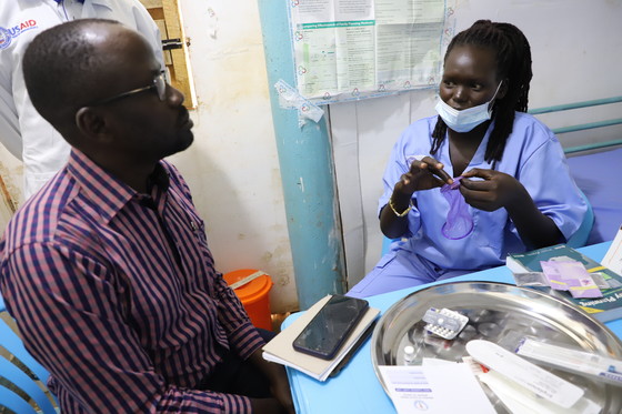 A clinician at Blessings Health Clinic in Juba describes to USAID's Dr. Jimmy Yuga family planning methods offered at the clinic. 