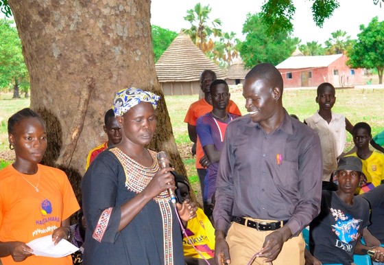 A community member speaks during a community dialogue on menstrual hygiene management awareness.