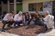 CHOCOLATE ARTISANS EXAMINE DRYING COCOA BEANS ALONGSIDE LOCAL STAKEHOLDERS AT THE WOMEN’S PENITENTIARY IN QUILLABAMBA.