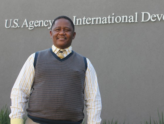Chris Mothupi, a locally led development champion, stands in front of the USAID Southern Africa Mission.