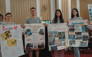 Moldovan participants in a volunteer training hold up posters on planning and leading volunteer group efforts.