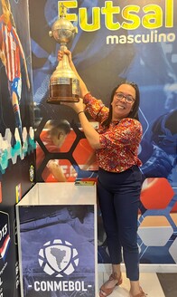 Sofia Mendez poses with a women’s soccer trophy at the CONMEBOL museum in Asuncion, Paraguay.