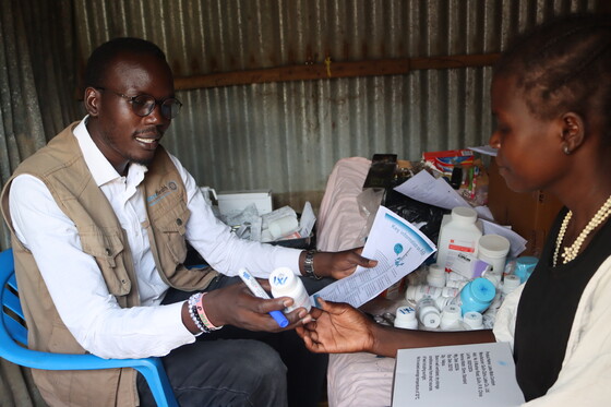 A clinician assists a patient at a USAID-supported clinic. Photo: USAID Advancing HIV & AIDS Epidemic Control Activity