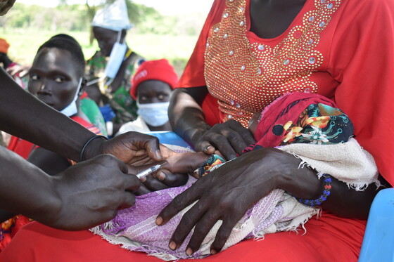 A child in Pokula village receives a vaccine