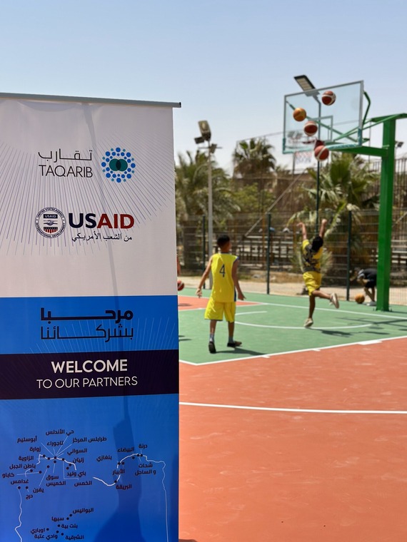 Children play basketball on newly renovated courts in Zwara, Libya.