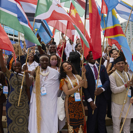 A group of youths holding flags from around the world.